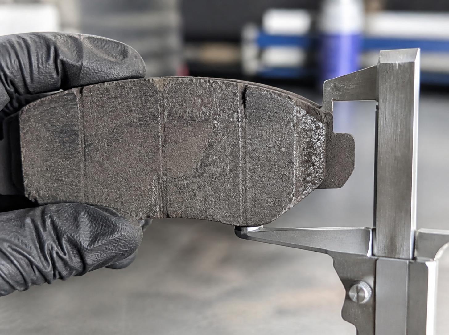 Photo of worn brake pad measured with a gauge